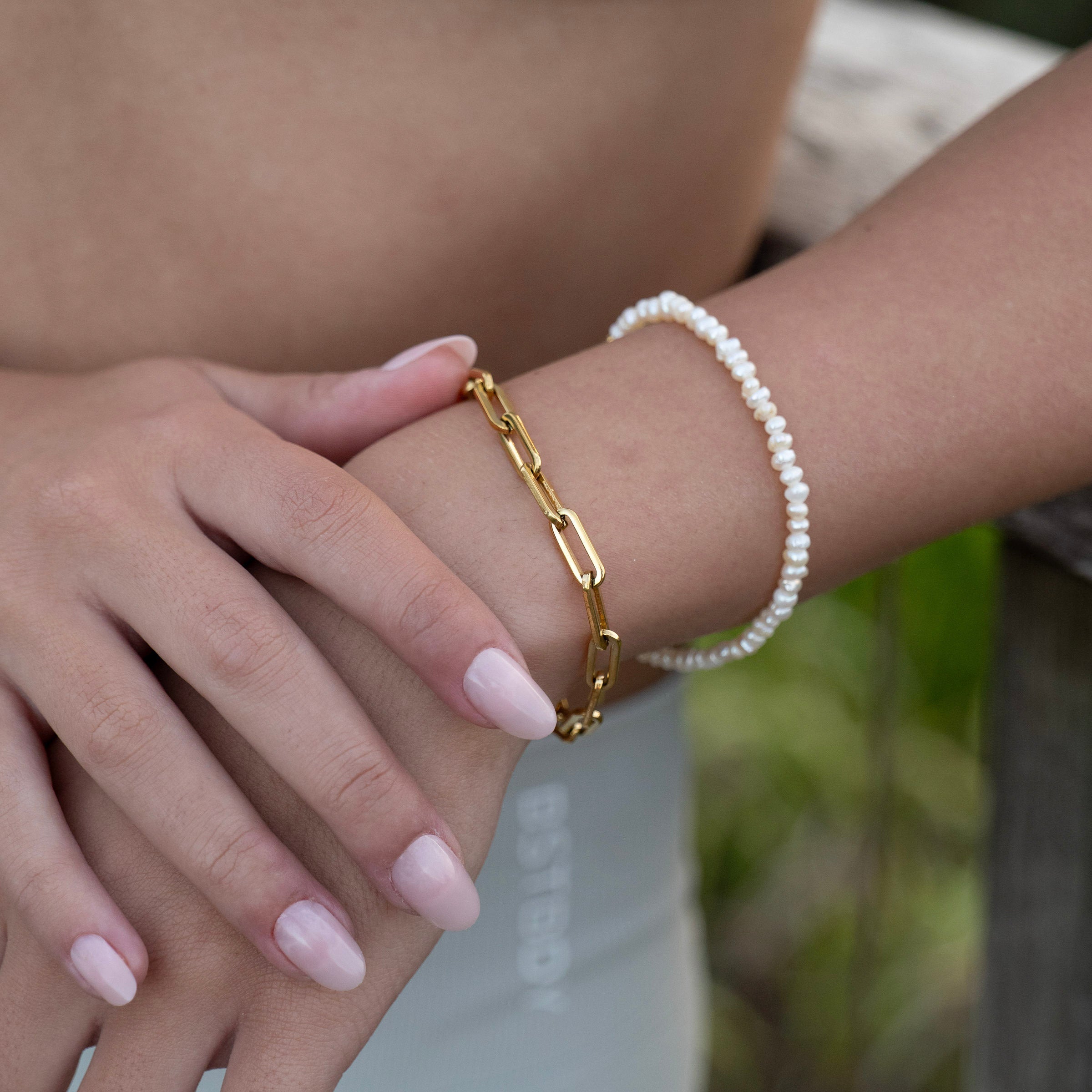 Freshwater pearl chain bracelet layered with gold chain