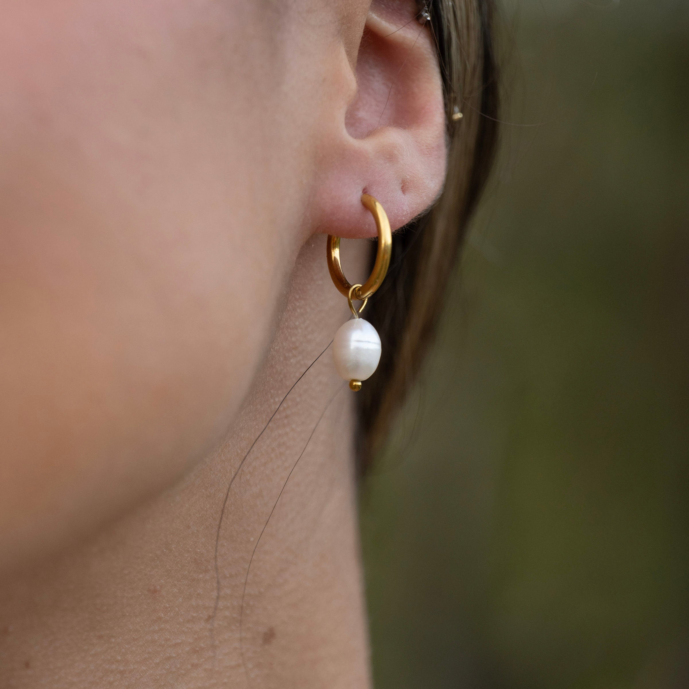 Waterproof gold PVD pearl drop hoop earrings on ear, tarnish-free stainless steel earrings