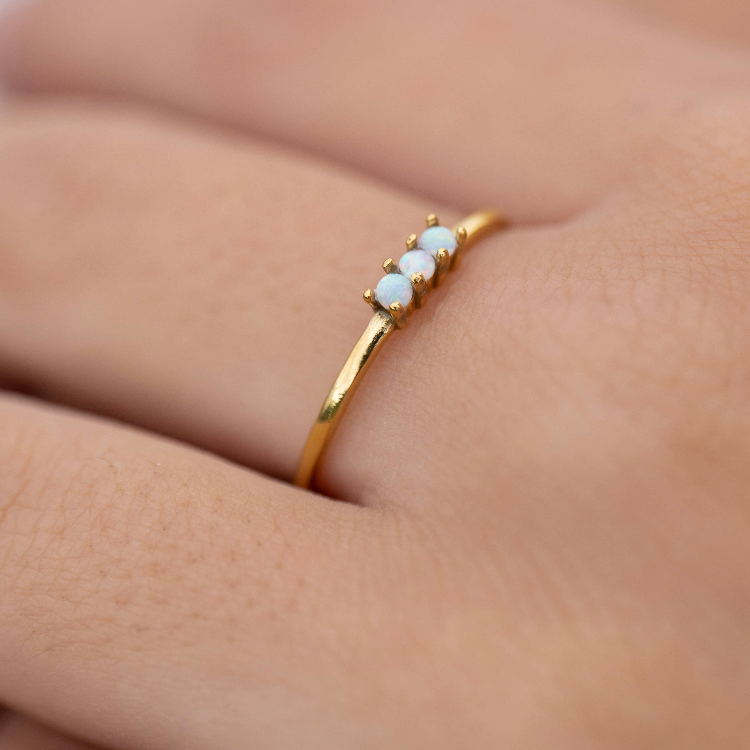 Gold opal stacking ring worn on hand