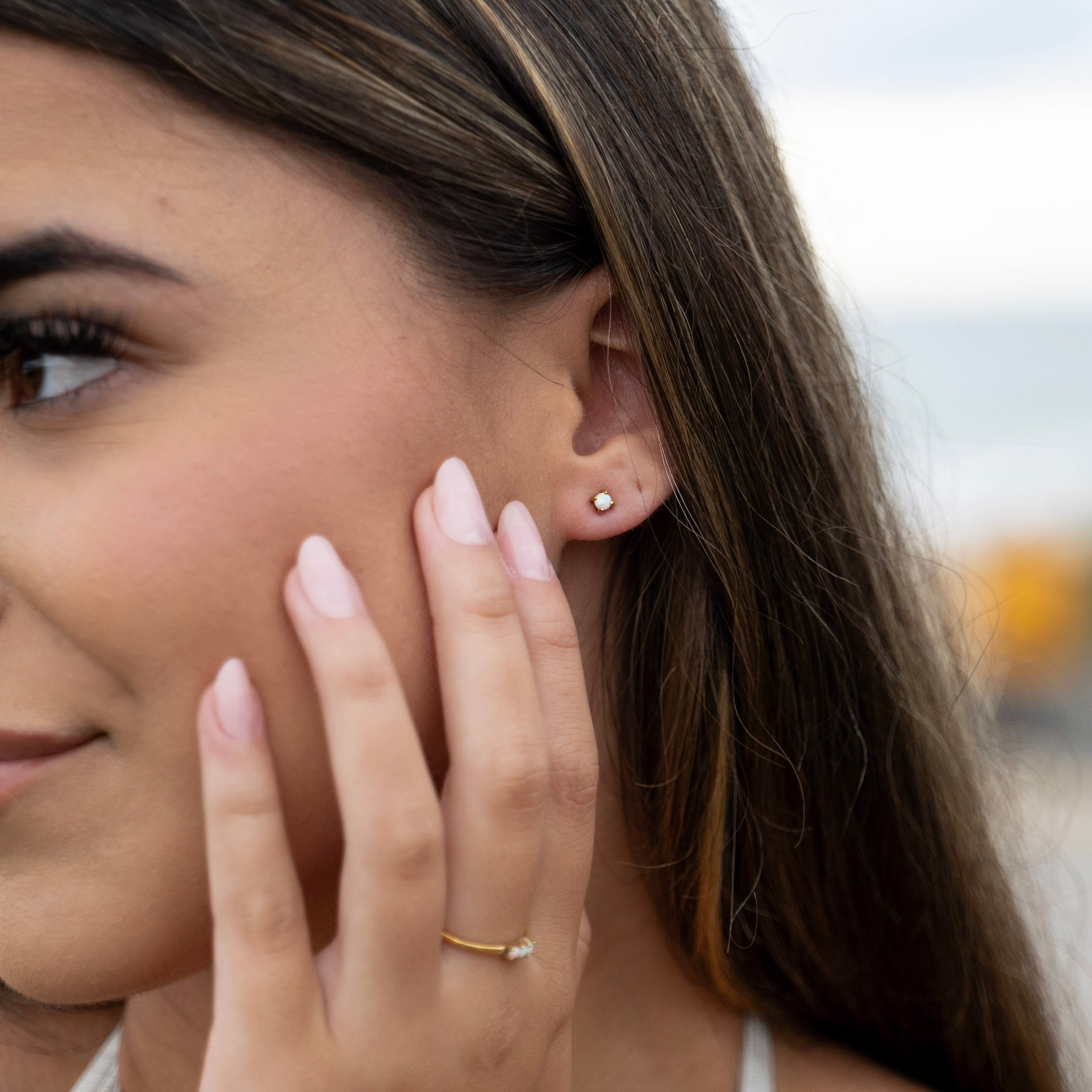 Minimal opal stud earrings worn close-up, waterproof PVD stainless steel gold studs designed for all-day wear