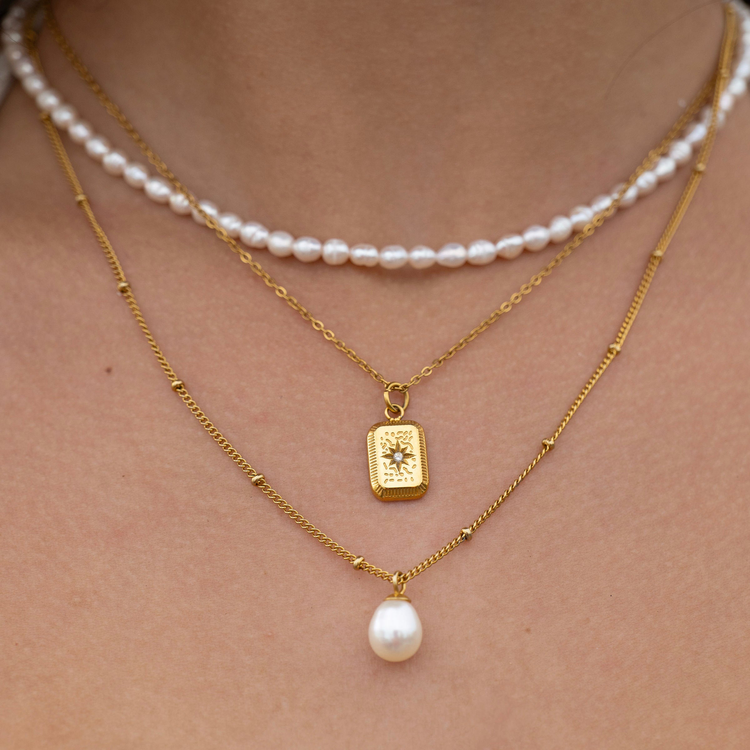 Waterproof gold layered necklace set styled together