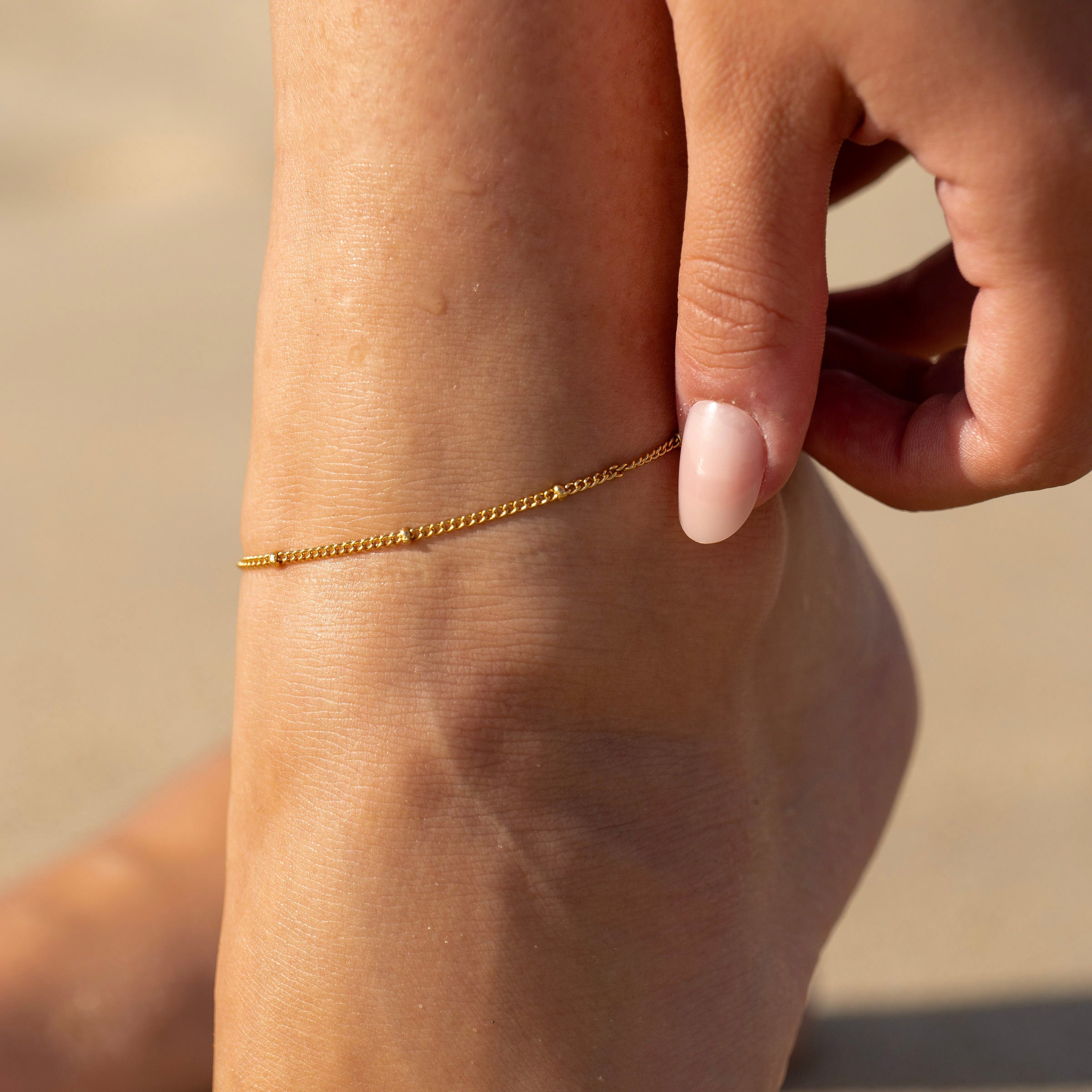 Waterproof gold ankle chain on sun-kissed skin