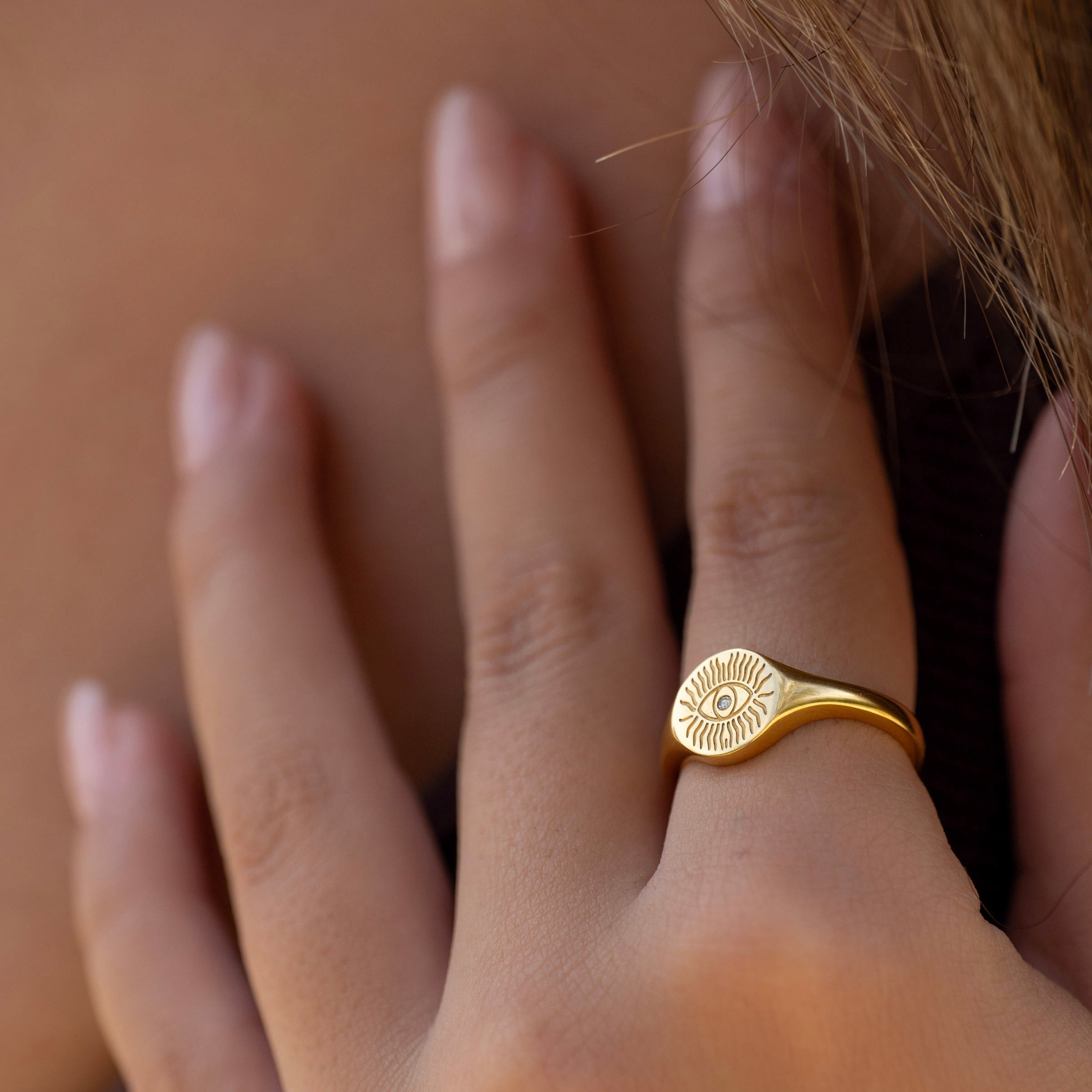 Waterproof gold PVD eye signet ring on hand, tarnish-free stainless steel ring