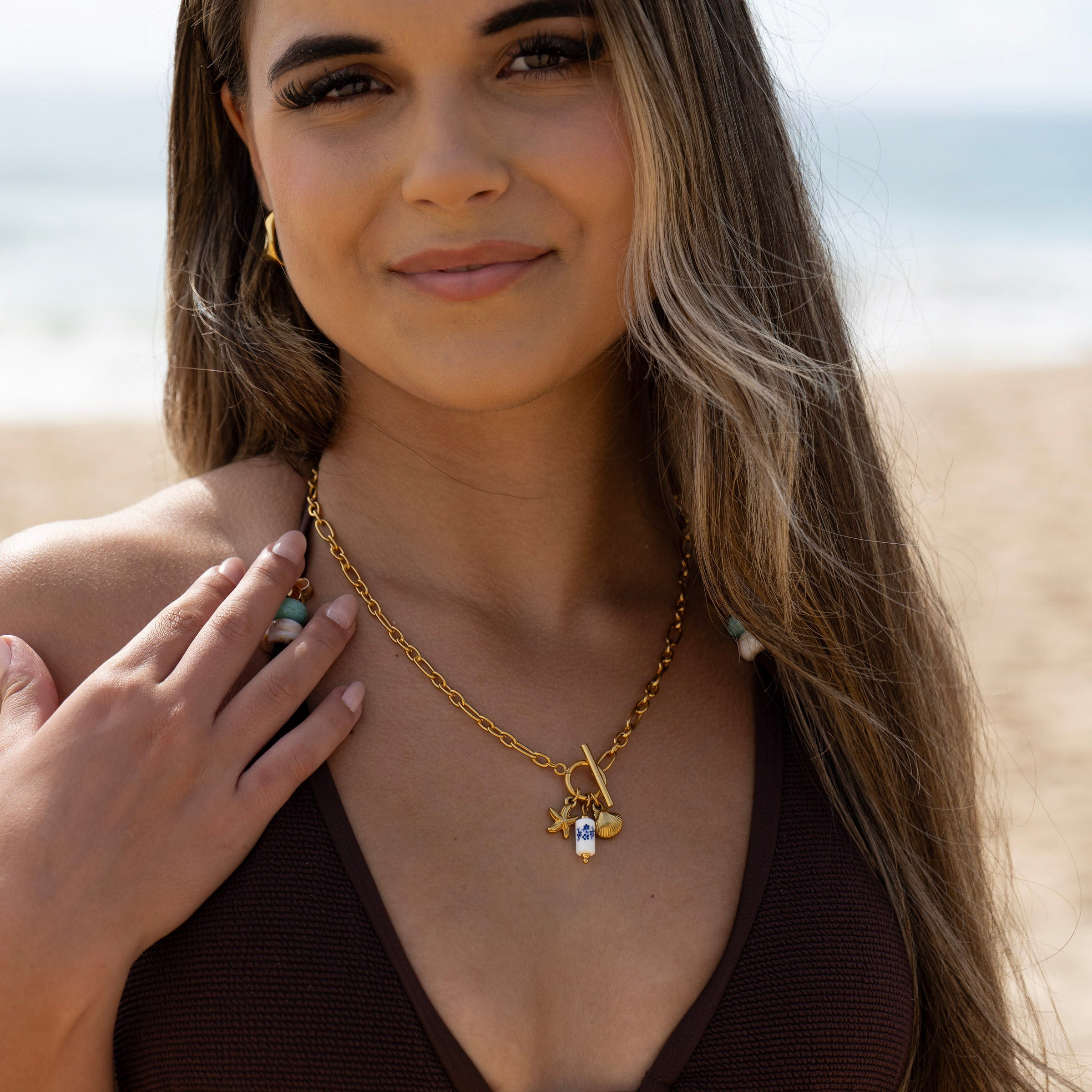 18K PVD gold charm necklace featuring starfish and shell details