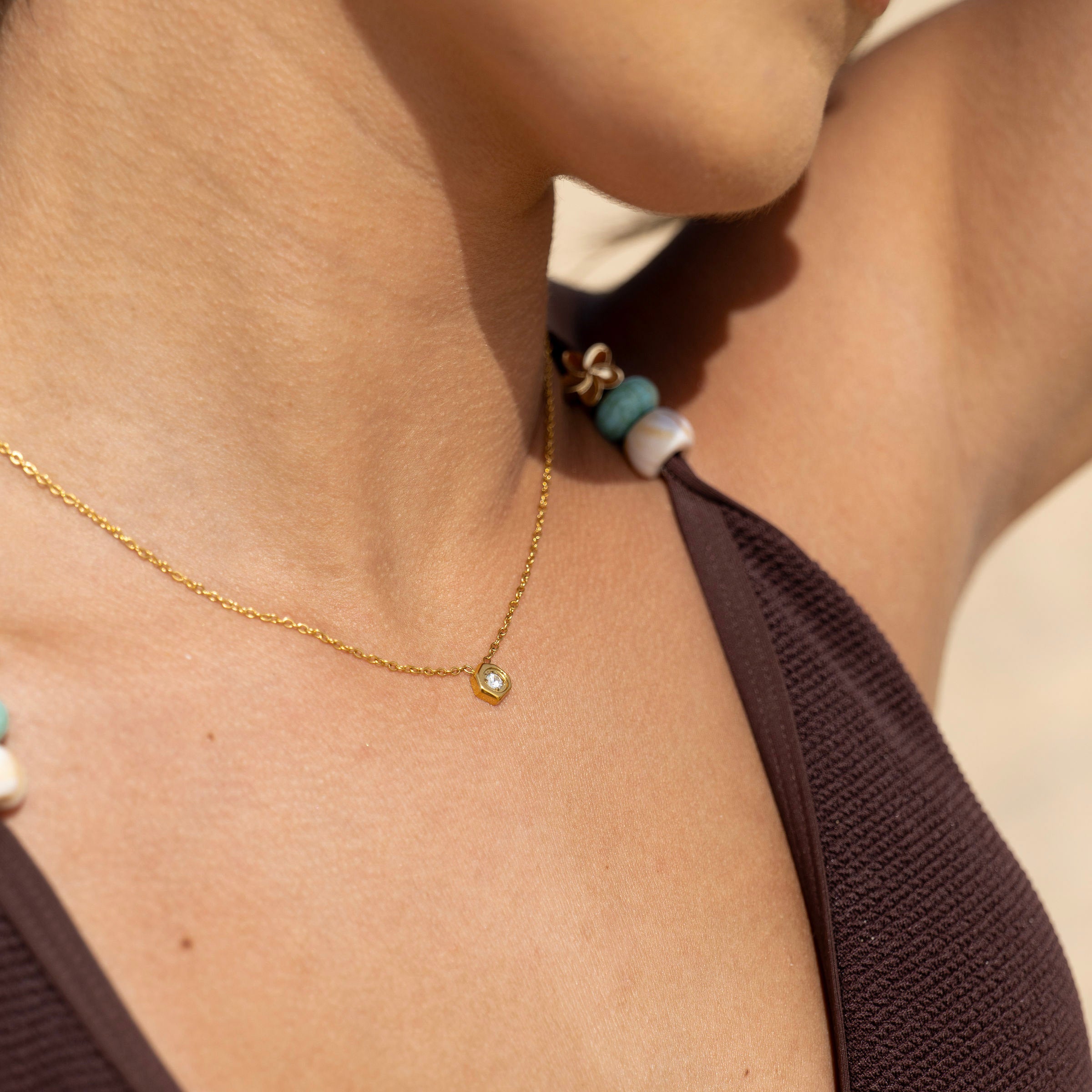 18K PVD gold necklace layered on sunlit skin