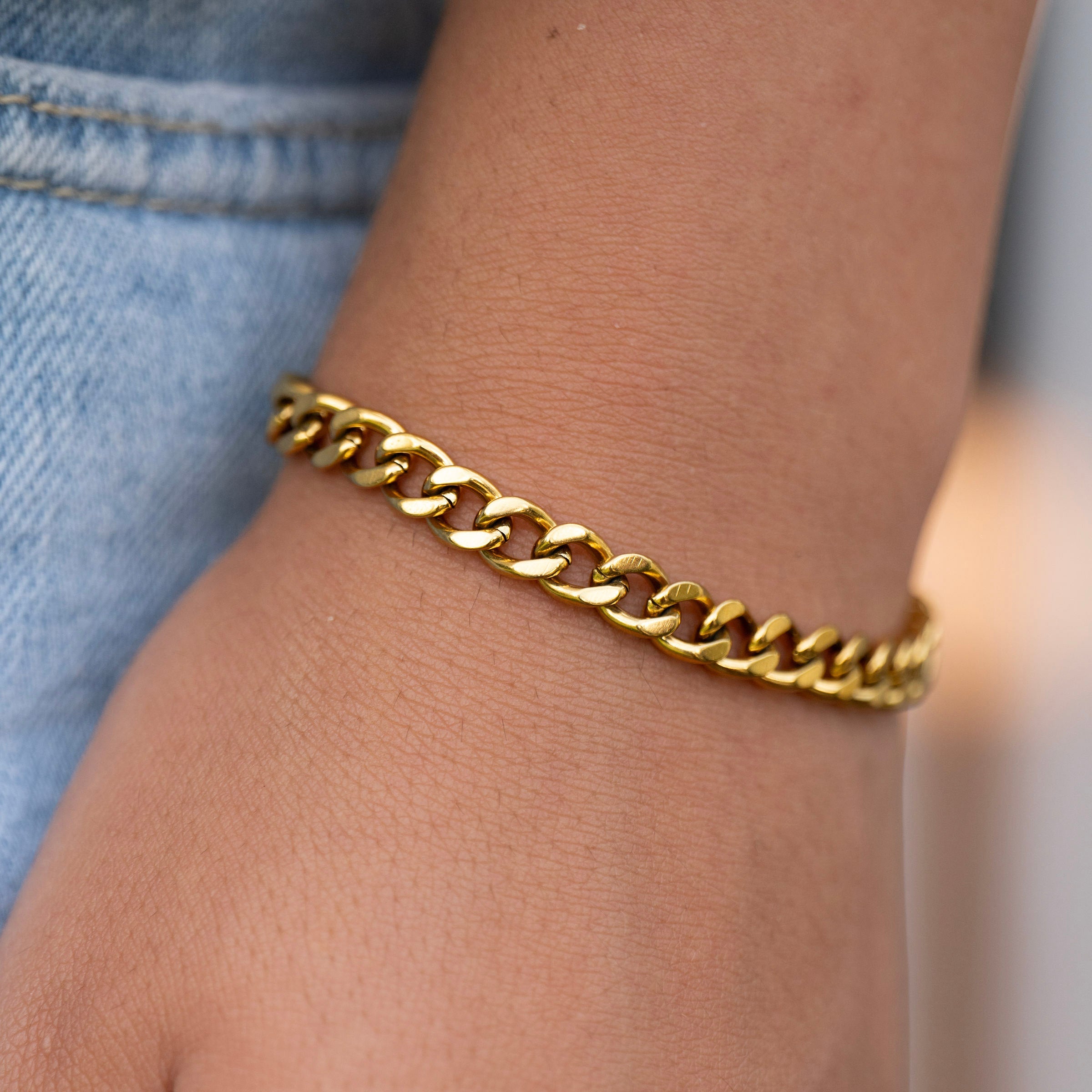 Gold curb chain bracelet worn on wrist, waterproof PVD stainless steel jewellery