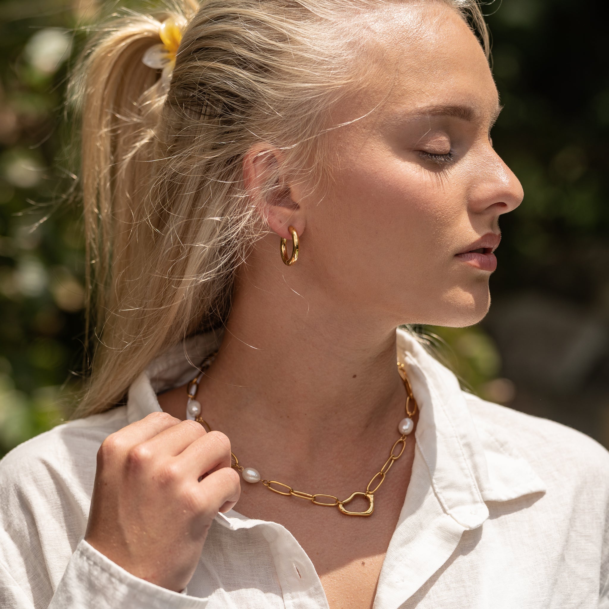 Gold Solace Curve Hoops close-up on ear