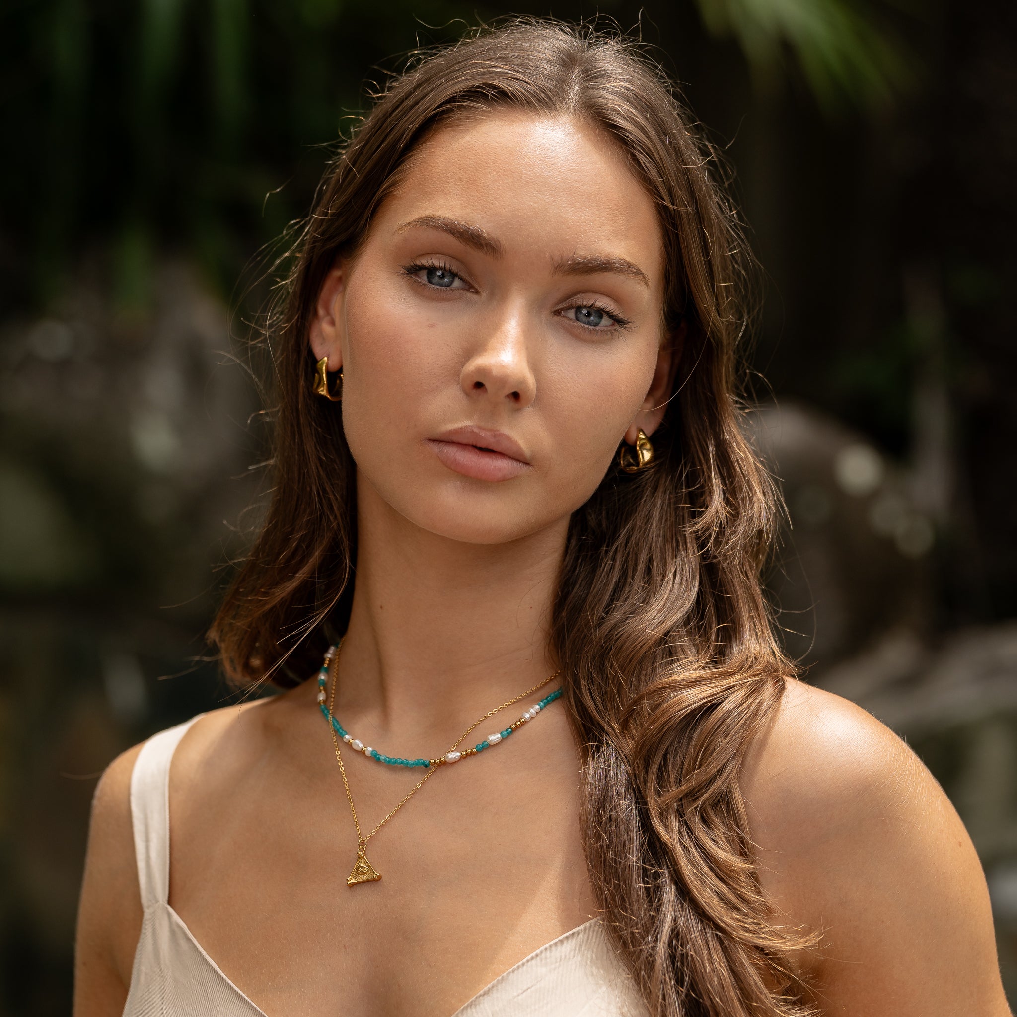 Azure Eye necklace stack featuring blue eye pendant layered with gold chains