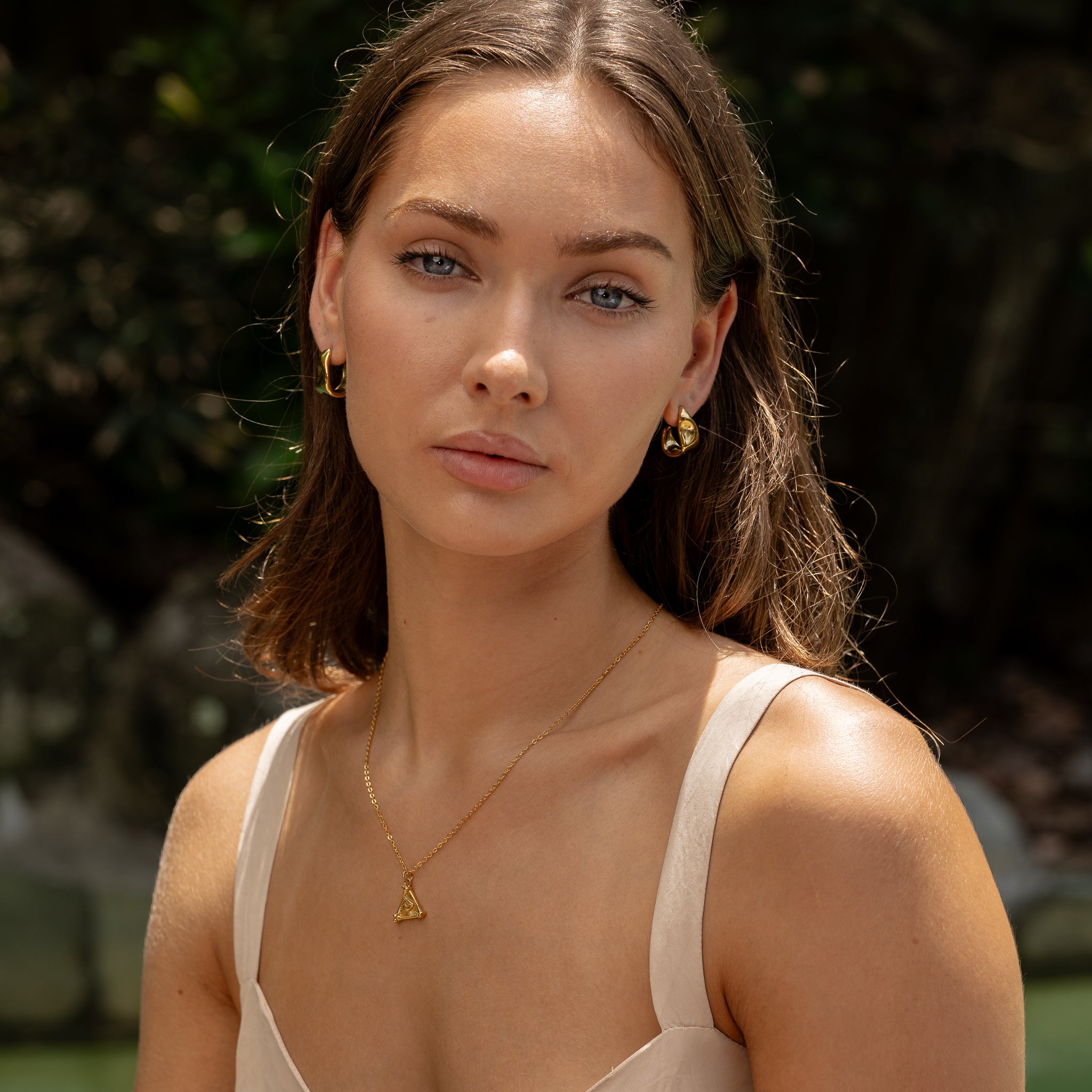 Lyria Flow Hoops worn on ear, 18K PVD gold sculptural wave form hoop, waterproof tarnish free Maevi jewellery