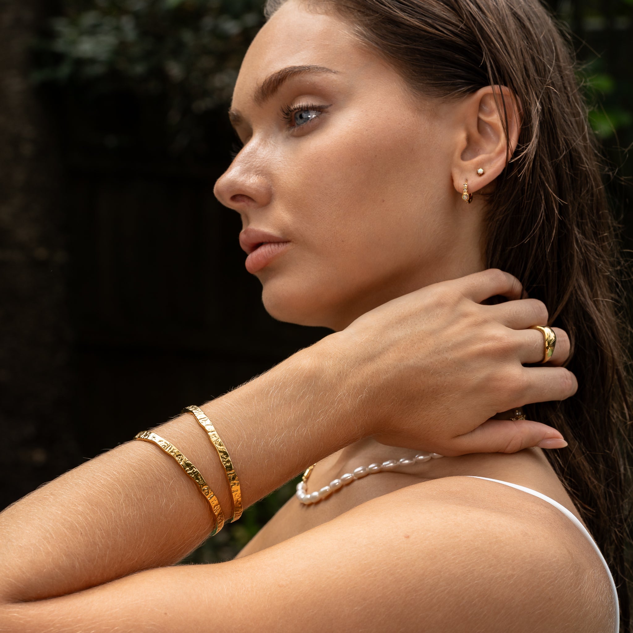 Close-up of the Erosion Cuff Bracelet stacked with other MAEVI gold jewellery — textured, tarnish-free cuff.