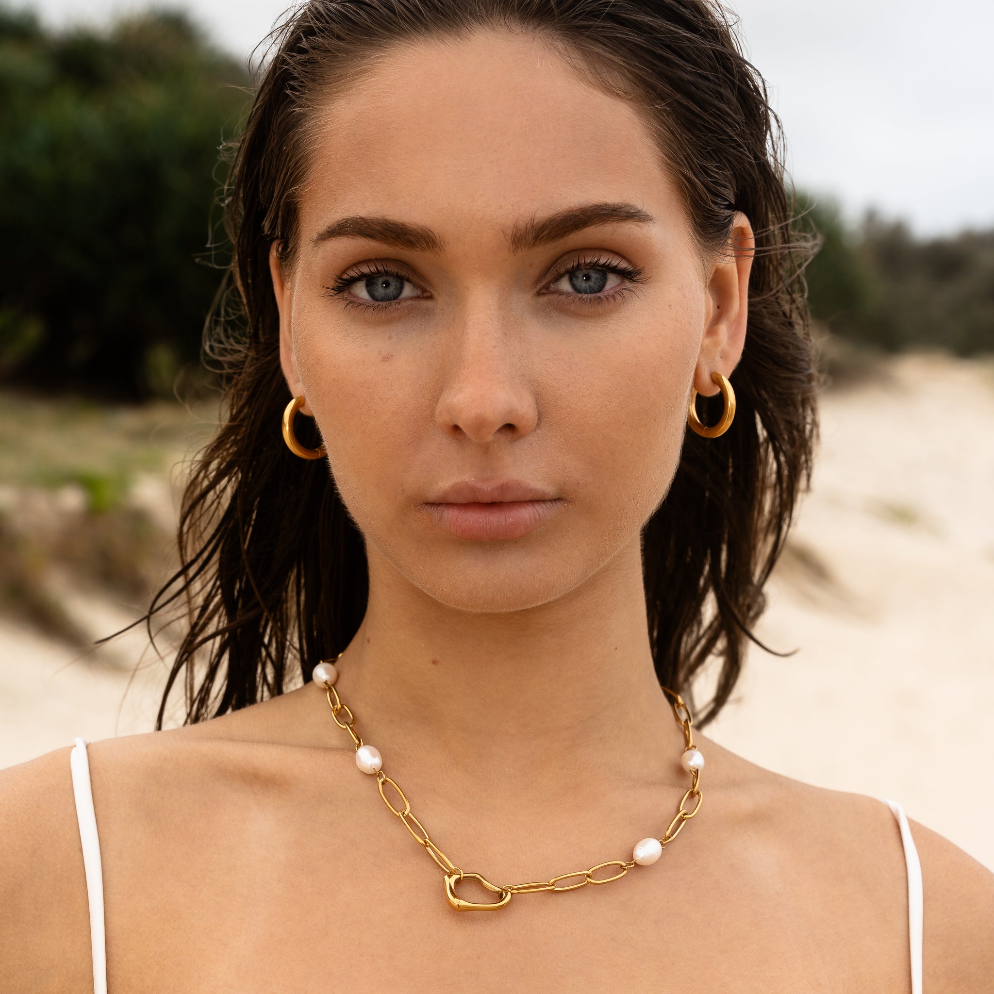 Solace Curve Hoops worn on ear — 18K PVD rounded gold hoop, waterproof tarnish-free Maevi
jewellery